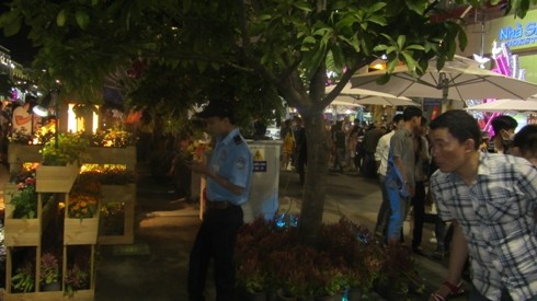 Bảo vệ của Nam Hải Sơn xem điện thoại khi đang làm việc tại đường hoa (ảnh: P.L)
