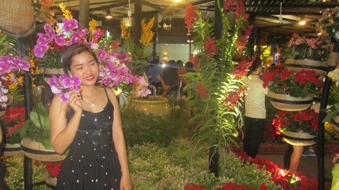 Thiếu nữ Sài Gòn xinh đẹp, nhưng thiếu ý thức giữ gìn vẻ đẹp của đường hoa khi tác động vào hoa lan (ảnh: P.L)
