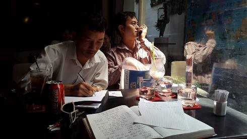 Anh Phạm Văn Đam (trái) đang viết đơn tố cáo hành vi của Trực trưa ngày 19/2 (ảnh: P.L)