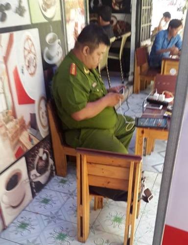 Thiếu tá Vĩnh ngồi chơi game bằng điện thoại trong quán cà phê khi còn là giờ làm việc (ảnh: P.L)