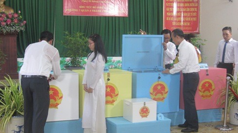 Nhân viên phục vụ điểm bầu cử thực hiện việc kiểm tra thùng phiếu dưới sự chứng kiến cử tri (Ảnh: P.L)