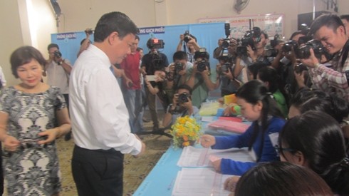 Bí thư Đinh La Thăng nộp thẻ cử tri để điểm danh cho nhân viên phục vụ điểm bầu cử (Ảnh: P.L)