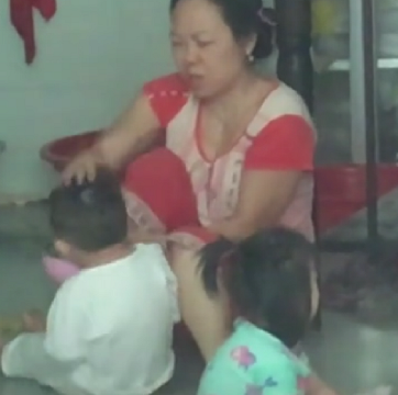 Cảnh bảo mẫu bạo hành với trẻ em tại cơ sở giữ trẻ tư thục không phép trên đường Nguyễn Oanh (ảnh từ clip)