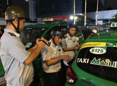 Lực lượng trật tự đô thị quận 1 đang niêm phong, chuẩn bị cẩu xe Mai Linh taxi vi phạm (ảnh: P.L)