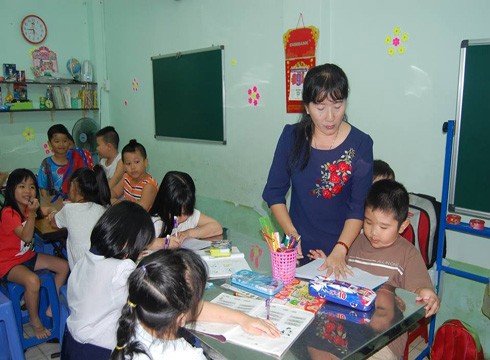 Cô Nguyễn Thị Hợp đang luyện chữ miễn phí cho trẻ em nghèo trong khu vực (ảnh: Đ.T)