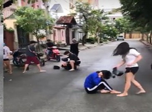 Nữ sinh mặc áo thun trắng dùng mũ bảo hiểm đánh bạn tới tấp ngoài đường (Ảnh từ video clip)