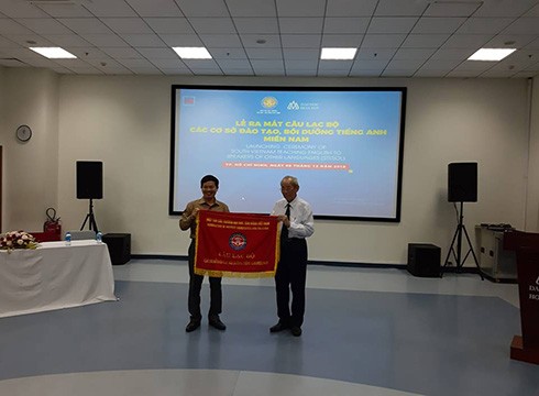 Giáo sư Trần Hồng Quân trao cờ cho Chủ nhiệm lâm thời của câu lạc bộ STESOL (ảnh: P.L)