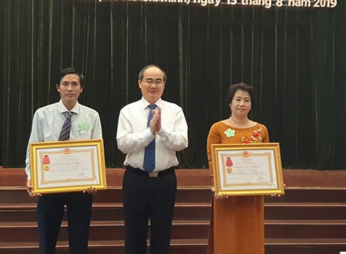 Bí thư Nguyễn Thiện Nhân (giữa) trao Huân chương lao động hạng 3 cho các trường học (ảnh: P.L)