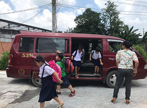 Học sinh Trường tiểu học Dĩ An xuống xe để đi vào các cơ sở giữ học sinh, ôn tập ngoài nhà trường (ảnh: P.L)