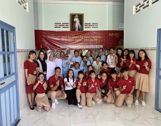 Học sinh iSchool Long An, đại diện NHG trao tặng tiền, quà cho Nhà Dưỡng lão tình thương Thanh Bình (ảnh: NHG)