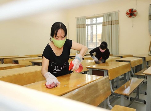 Nhân viên trường trung học phổ thông Trần Quang Khải lau chùi bàn ghế sạch sẽ trước ngày học sinh đi học lại (ảnh: P.L)