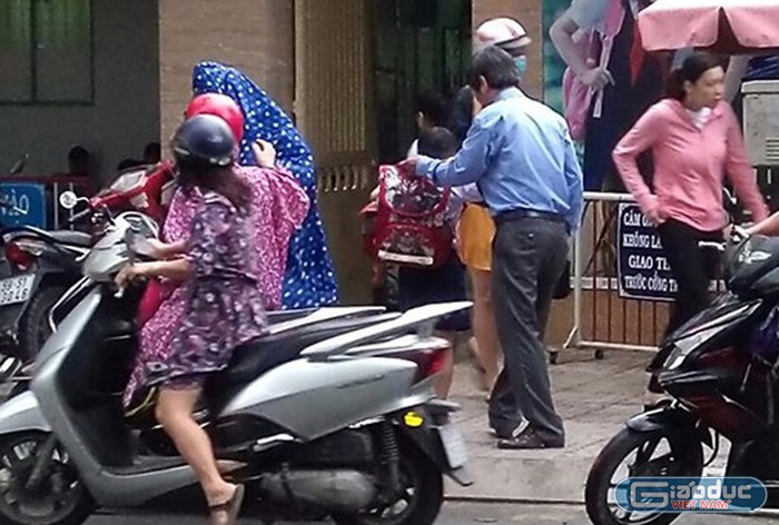 Thầy Hùng (áo xanh) đón học sinh trước cổng trường (ảnh: N.V.H)