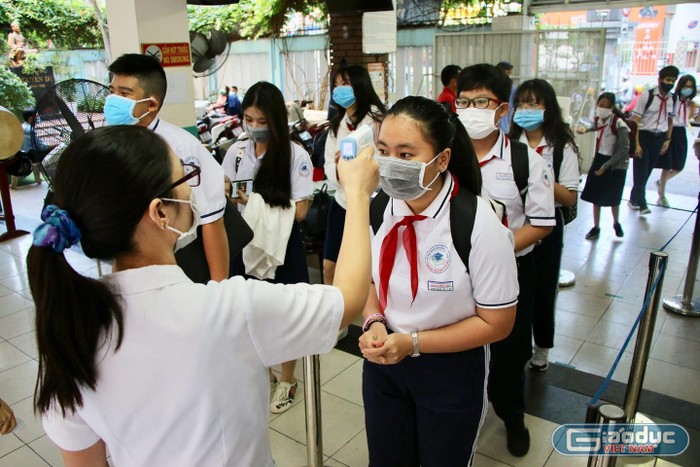 Học sinh trường Trung học cơ sở Nguyễn Du, quận 1 được đo thân nhiệt từ cổng (ảnh: NTCC)