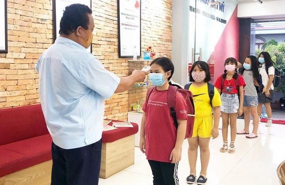Học sinh tỉnh Đồng Nai nghiêm túc đeo khẩu trang, đo thân nhiệt mùa dịch (Ảnh: Báo Đồng Nai)