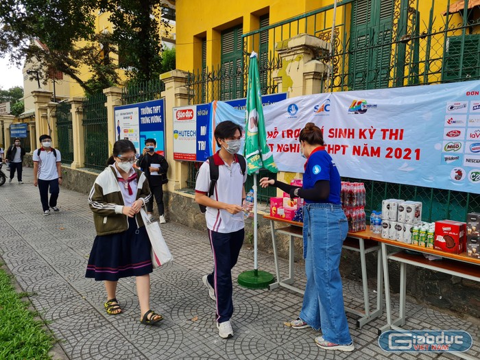 Sinh viên tình nguyện hỗ trợ, giúp sức các thí sinh bên ngoài điểm thi Trưng Vương (ảnh: P.L)