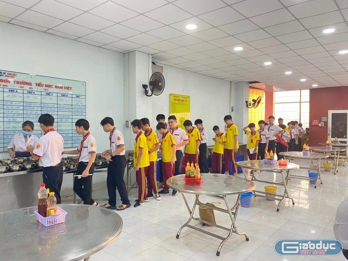 Học sinh Trường tiểu học, trung học cơ sở - trung học phổ thông Nam Việt trật tự xếp hàng đi lấy bữa ăn trưa bán trú. (Ảnh: P.L)