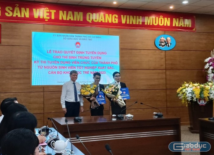 Giám đốc Sở Giáo dục và Đào tạo Thành phố Hồ Chí Minh trao quyết định tuyển dụng cho hai sinh viên xuất sắc (ảnh: V.D)
