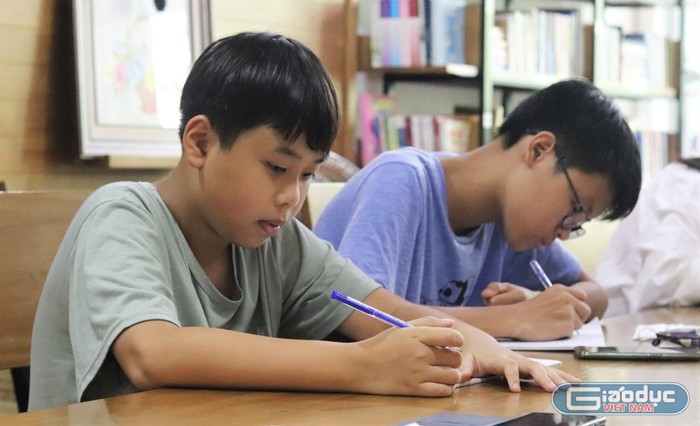 Học sinh Chu Bảo Châu (bên trái) chia sẻ, tham gia lớp học giúp cậu mở mang hơn nhiều. (Ảnh: Ngân Chi).