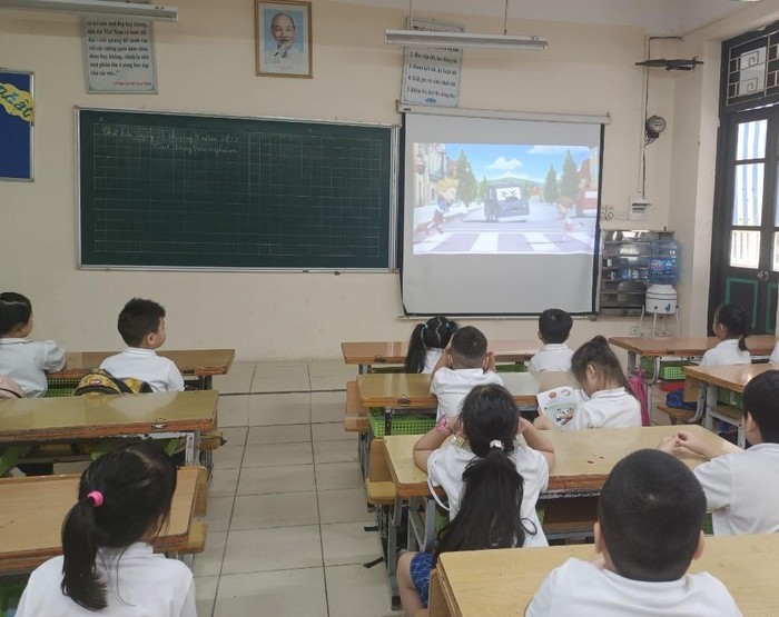 Học sinh Trường Tiểu học Quang Trung theo dõi thông tin tuyên truyền An toàn giao thông. (Ảnh: NTCC).