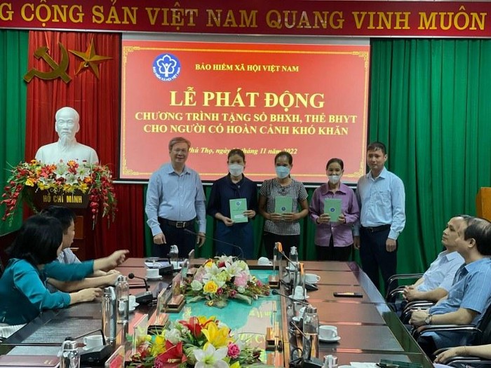Trần Thị Tân (thứ 2 từ trái sang phải) nhận sổ bảo hiểm xã hội tại lễ phát động tặng sổ bảo hiểm xã hội, thẻ bảo hiểm y tế.