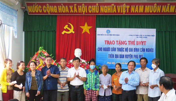 Phó Giám đốc Bảo hiểm xã hội tỉnh Đặng Văn Lý tặng thẻ bảo hiểm y tế cho người dân thuộc hộ cận nghèo huyện Phù Mỹ.
