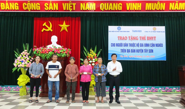 Phó Giám đốc Bảo hiểm xã hội tỉnh Đặng Văn Lý tặng thẻ bảo hiểm y tế cho người dân thuộc hộ cận nghèo huyện Tây Sơn.