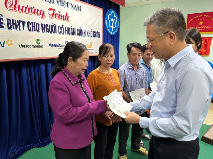 Phó Tổng Giám đốc Bảo hiểm xã hội Việt Nam Trần Đình Liệu trao sổ bảo hiểm xã hội, thẻ bảo hiểm y tế cho người dân.