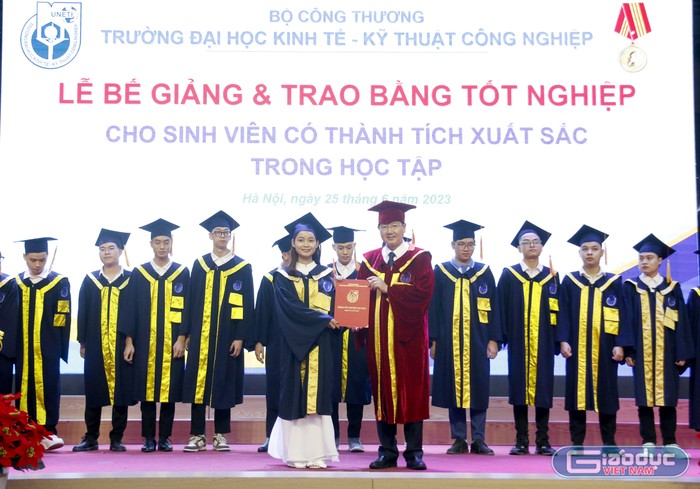 Tiến sĩ Trần Hoàng Long - Hiệu trưởng Trường Đại học Kinh tế - Kỹ thuật Công nghiệp trao bằng cho sinh viên tốt nghiệp xuất sắc.