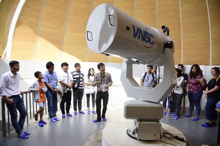 Sinh viên tham quan và nghe Tiến sĩ Phạm Tuấn Anh giảng về cấu trúc vũ trụ tại Trung tâm Vũ trụ Việt Nam. Ảnh: NTCC.