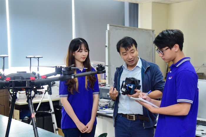 Tiến sĩ Tống Sĩ Sơn - Phó Trưởng khoa, khoa Vũ trụ và Ứng dụng (Trường Đại học Việt Pháp) hướng dẫn sinh viên sử dụng camera siêu phổ. Ảnh: NTCC.