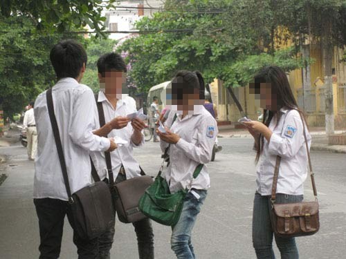 Thí sinh dự thi tại trường THPT Lê Quý Đôn (Hà Nội) trao đổi "phao" thi trước giờ vào thi tại kỳ thi tốt nghiệp THPT 2011.