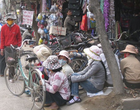 Những người lao động nữ ngồi túm tụm trong cảnh "đói việc" tại khu vực gần cổng chợ Phùng Khoang (Từ Liêm, Hà Nội).