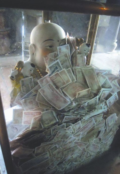 Tượng Phật Di Lặc ngập trong tiền lẻ.