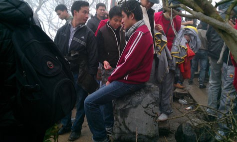 Người thanh niên này vô tư ngồi trên một tấm bia tại di tích Hoa Yên (Yên Tử). (Ảnh: Thế Long).