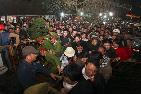 Xổ đổ cả hàng rào, chèn cảnh sát để vào lễ khai ấn đền Trần đêm ngày 14 vừa qua. (Ảnh: Tuổi trẻ).