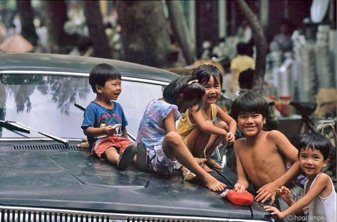Những cô bé, cậu bé với nụ cười vui thích bên một chiếc ô tô hạng sang lúc bấy giờ.