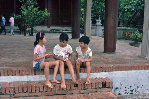 Các cô bé, cậu bé Hà Nội của thập niên 90 trò chuyện trong khuôn viên một di tích.