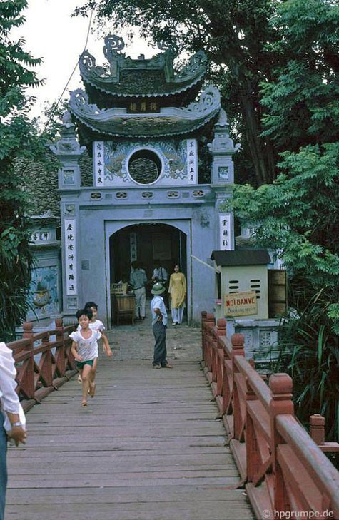 Hai em nhỏ chạy chơi trên cầu Thê Húc.