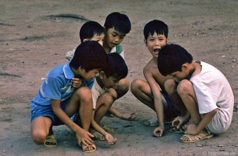 Các cậu bé thích thú với trò chơi bắn bi, một trò chơi thường thấy của em nhỏ Hà Nội những năm 90