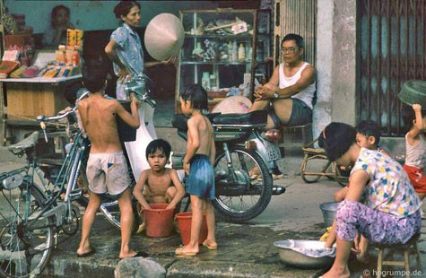 Các cậu bé cùng thi nhau tắm gội ngay trên vỉa hè một con phố. Đây là cảnh thường thấy vào những năm 90 của thập niên trước.