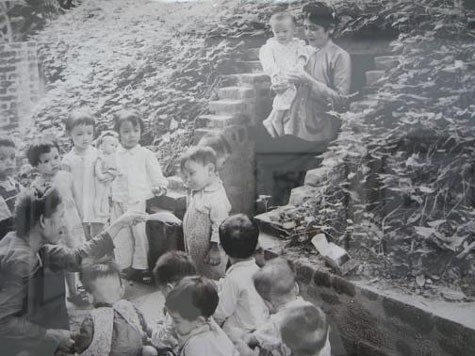 Trẻ em Hà Nội vui chơi trước một hầm trú ẩn trên phố Thợ Nhuộm trong thời kỳ chiến tranh phá hoại