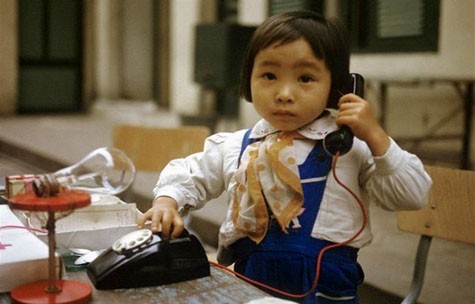 Một cô bé nghịch chiếc điện thoại tại một nhà trẻ ở Nghi Tàm (Hà Nội) năm 1973.