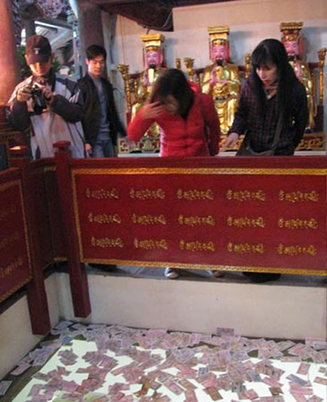 Tiền lẻ rải đầy trên tấm kính ở chùa Phật Tích (Bắc Ninh).