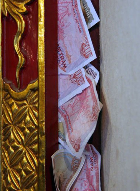 Không đặt được ở bên trong, nhiều người còn gài tiền lẻ ngay ở các khe cửa của nhiều ngôi chùa.