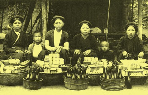 Hai cậu bé Hà Nội bán hàng cùng với mẹ trong một phiên chợ xưa.