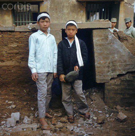 Hai cậu bé Hà Nội mang trên đầu chiếc khăn trắng tang tương sau những cuộc công kích của máy bay Mỹ vào phố Khâm Thiên năm 1972 gây thiệt hại nặng về người và nhà cửa của nhân dân thủ đô.