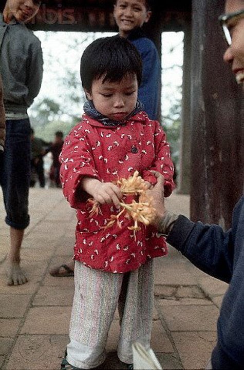 Một em bé Hà Nội đón nhận quà từ người lớn năm 1973.