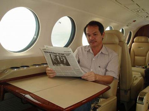 Bầu Đức ngồi đọc báo trên máy bay riêng của mình.