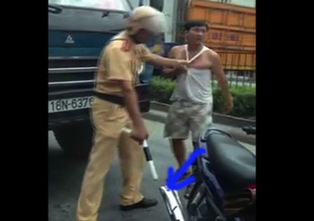 Lôi tài xế về phía chiếc xe máy của người cảnh sát để anh ta cho xem phần bô xe bị méo. (ảnh cắt từ video)