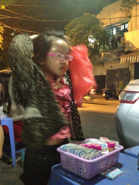 Hình ảnh cô bé bán kẹo cao su bị mẹ đánh bươu đầu khiến cư dân mạng phẫn nộ (Ảnh từ facebook Tran Quang Minh).